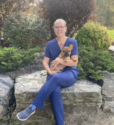 Leslie sitting with her dog, Gus